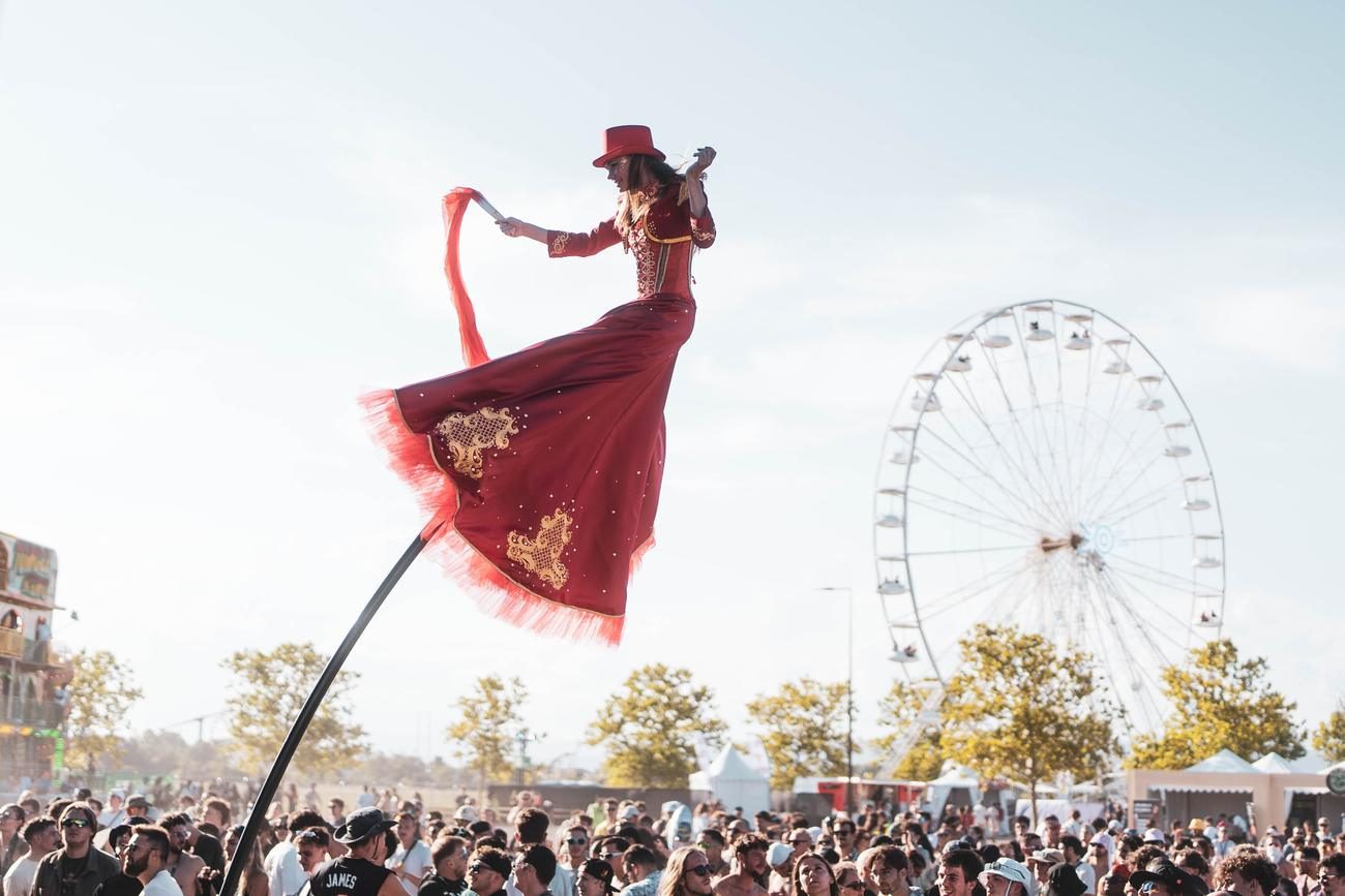 Échassière en robe rouge au festival Elektric Park